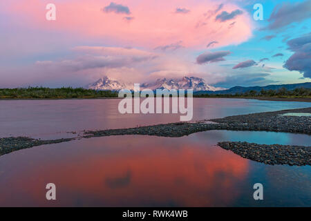 Pink and blue colour sunrise along the Serrano river with the Andes peaks of the Torres del Paine national park in the background, Patagonia, Chile. Stock Photo