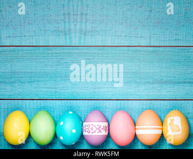 Colorful Easter Eggs arranged in a row on a blue background. Stock Photo