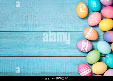 Colorful Easter Eggs arranged to one side on a blue background. Stock Photo