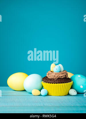 Easter Eggs and cupcake with Candy on a blue background. Stock Photo
