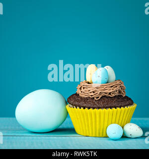 Easter Eggs and cupcake with Candy on a blue background. Stock Photo