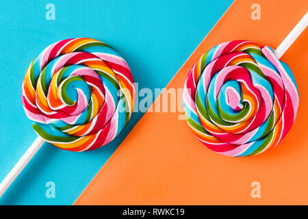 Colorful lollipops on blue and orange background. Stock Photo