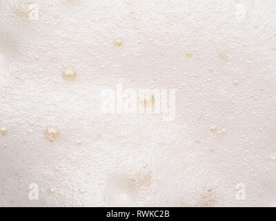 Foam texture extreme close up as background. Beer or cappucino foam with bubbles macro shoot. Copy space for text. Stock Photo
