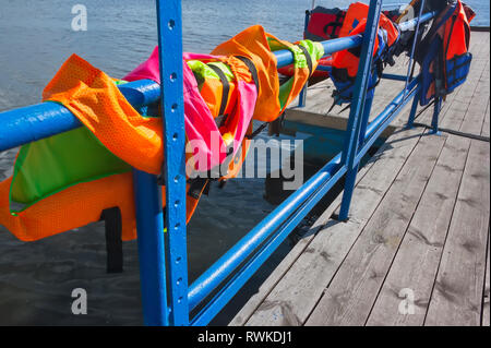 life jackets on the handrails of the berth for tourist boats Stock Photo