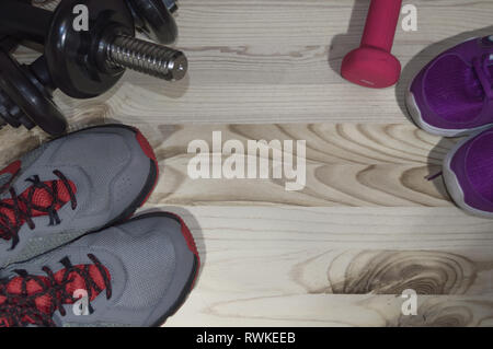 dumbbells and sport snickers on wooden background with space for text Stock Photo