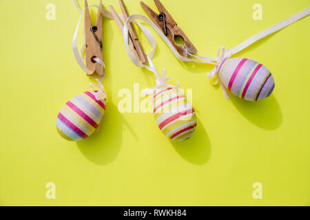 Eggs painted various patterns for Easter holiday. Yellow bright background, copy space, minimalistic concept.Stylish Candy color easter eggs .Spring Stock Photo