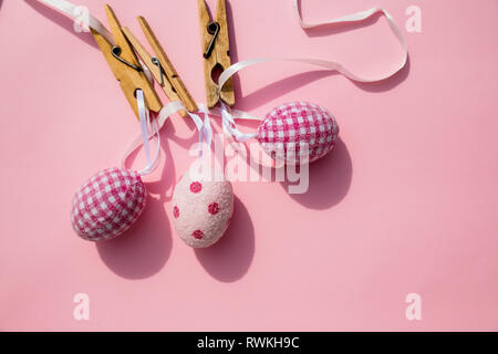 Many easter eggs on trendy pink pastel background. Eggs are hand-drawn. Flat lay style.Top view of easter eggs colored in differen patterns. Various Stock Photo