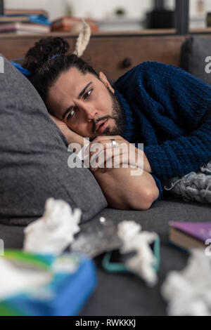 Sad cheerless man resting on the sofa Stock Photo