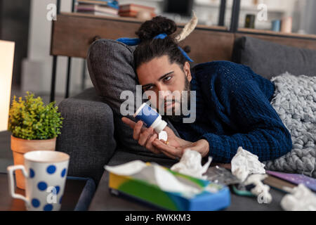 Sad cheerless young man feeling very bad Stock Photo