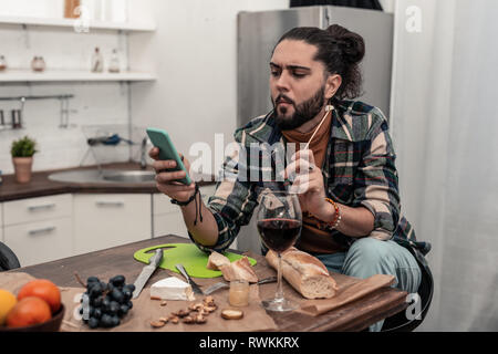 Nice thoughtful young man browsing the Internet Stock Photo
