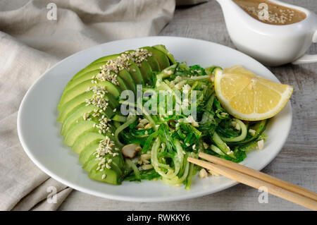 Chukka salad, cucumber noodles with avocado and peanut brown sauce in sauceboat Stock Photo