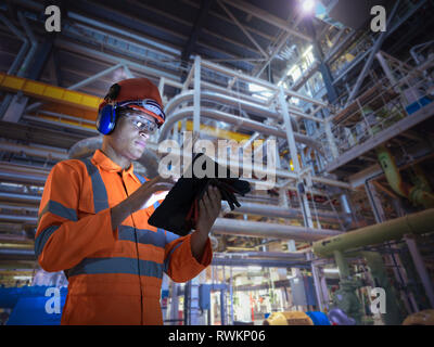 Composite image of engineer in nuclear power station using digital tablet