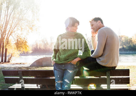 Couple looking worried on park bench, Strandbad, Mannheim, Germany Stock Photo