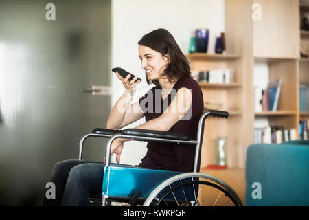 Woman in wheelchair using cellphone Stock Photo