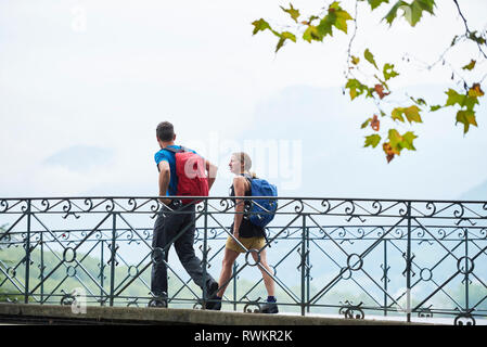 Man and young woman strolling along river footbridge, portrait, Annecy, Rhone-Alpes, France Stock Photo