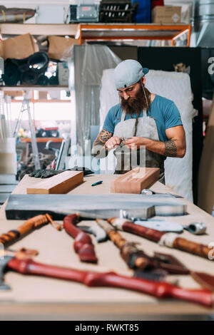 Axe working on wood for axe handle in workshop