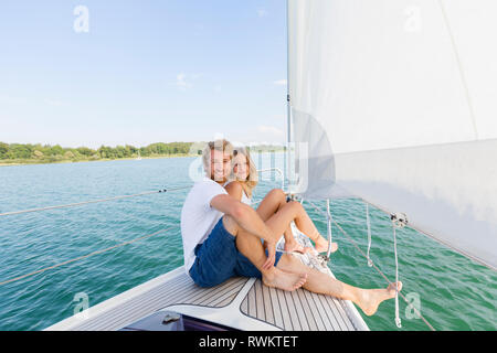 Young couple sailing on Chiemsee lake, portrait, Bavaria, Germany Stock Photo