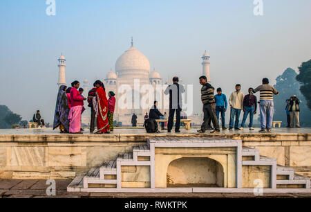 INDIA, AGRA; A group of Indian tourists enjoying the spectacular view of Taj Mahal early in the morning Stock Photo