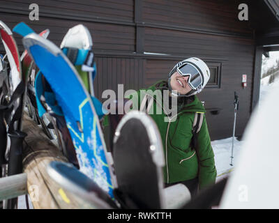 Young woman skier wearing helmet and ski goggles outside ski hut,  portrait, Alpe Ciamporino, Piemonte, Italy Stock Photo