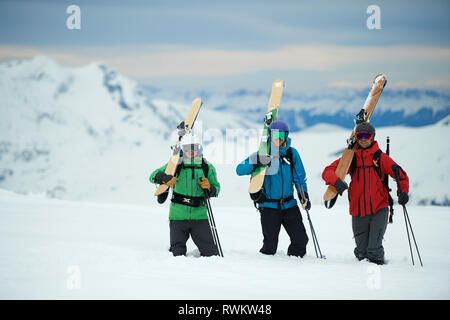 Landscape with three male skiers carrying skis, portrait, Alpe-d'Huez, Rhone-Alpes, France Stock Photo