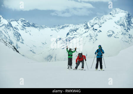 Landscape with three male skiers, portrait, Alpe-d'Huez, Rhone-Alpes, France Stock Photo