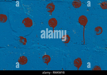 The section of the wall, painted with blue paint with burgundy patches Stock Photo