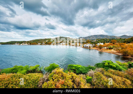 Moody view of Gumusluk bay and village in Bodrum, Mugla, Turkey on a cloudy winter day. Beautiful calm sea, sky and meadow landscape. Stock Photo