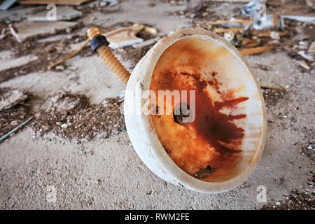 Rusty and dirty marble sink thrown away on the floor of an abandoned building Stock Photo