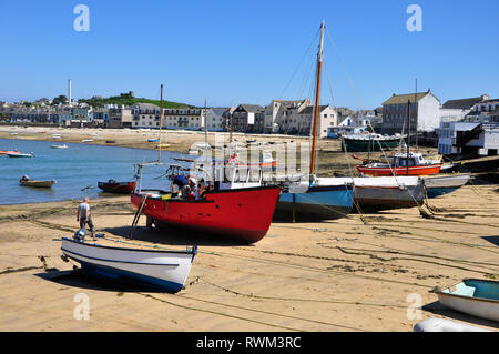 Fishermen working on their boats on the beach in Hugh Town, St Mary's, Isles of Scilly. Stock Photo