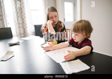 Mother watching over son learning at table Stock Photo