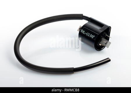 Complete ignition coil for a Yamaha motorcycle engine of 125 c.c. four-stroke isolated on white. Image taken in Spain on March 6, 2019. Stock Photo