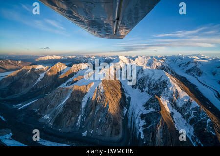 Aerial image of the Saint Elias mountains in Kluane National Park and Reserve with a view of the bottom of an airplane wing Stock Photo