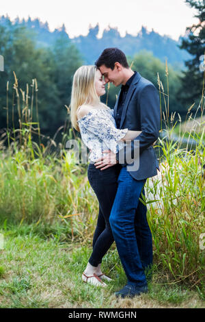 A young couple standing in an embrace; Bothell, Washington, United States of America Stock Photo