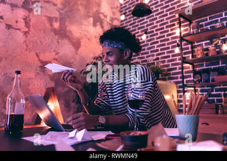 African American young man making a successful airplane model and enjoying it with smile. Stock Photo