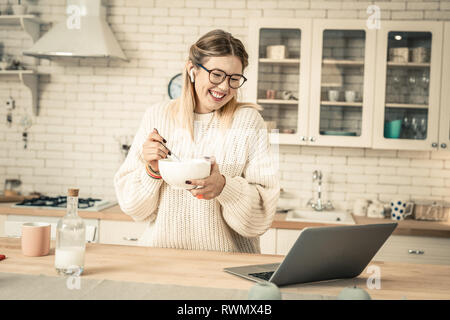 Cheerful attractive woman with wide smile carrying bowl with breakfast Stock Photo