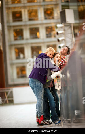Three friends having fun ice-skating together. Stock Photo