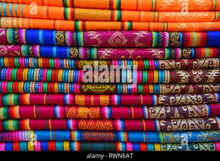 Colourful pile of textiles on the indigenous market of Otavalo, Ecuador. These textiles can be found in the Andean world: Peru, Bolivia, Ecuador. Stock Photo