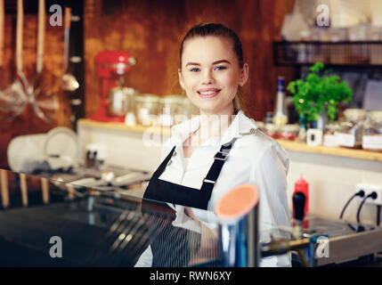 Portrait of a happy young woman working in a coffee shop Stock Photo