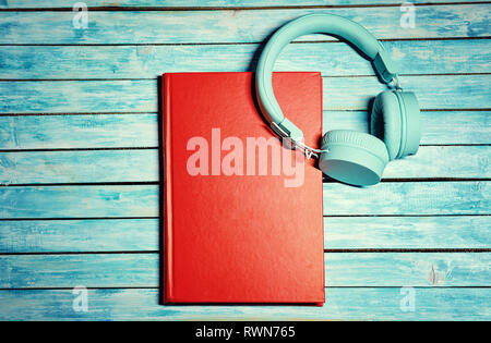 Headphones over books. Wooden Table. Reading and Audio books concept Stock Photo