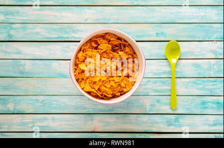 Cornflakes bawl on a vintage wooden table. Spoon. Organic Food Stock Photo