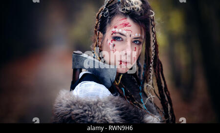 Warrior Beauty with trace of blood on her face. Viking Woman. Close-up portrait. Cinematic look Stock Photo
