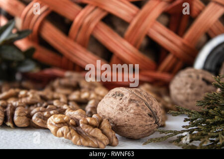 Walnuts and kernels of nuts on a white background near the basket. Stock Photo