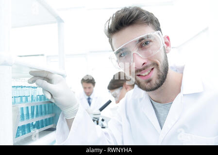 Young male scientist looking at a sample in a test tube side vie Stock Photo