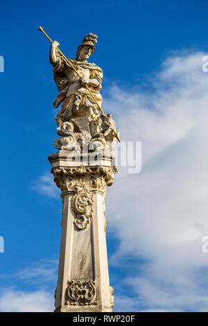 Close-up of the statue of Saint George slaying a dragon with a spear on top of Saint George's Fountain with blue sky and clouds; Trier, Germany Stock Photo