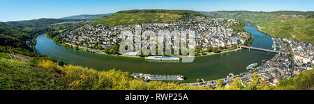 Panorama view of riverside village along the curve of the river with hillside vineyards on steep slopes and blue sky; Bernkastel, Germany Stock Photo