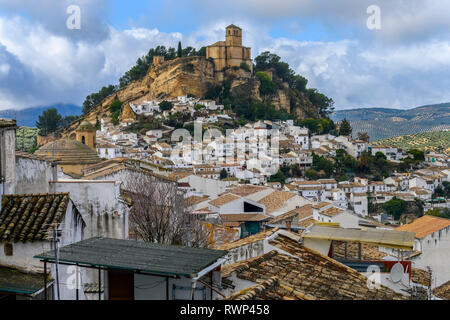 Ruins of a Moorish castle on a hilltop with houses filling the hillside and olive groves in the rolling hills; Montefrio, Province of Granada, Spain Stock Photo