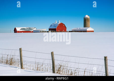 Barn in snow covered field Stock Photo