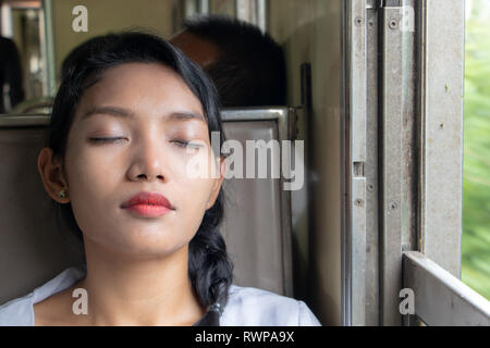 Portrait of young woman sleeping in the train. Passenger sleep in the old wagon of a train. Stock Photo