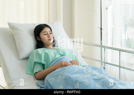 Asian patient woman sleeping and lying on her bed while receiving in hospital. Stock Photo