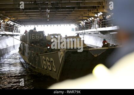 190305-N-KO533-0031  ATANTIC OCEAN (Mar. 5, 2019) A Landing Craft Utility delivers Lighter Amphibious Resupply Cargo five ton vehicles to the amphibious assault ship USS Bataan (LHD 5) during well-deck operations. The ship is underway conducting sea trials. (U.S. Navy photo by Mass Communication Specialist 3rd Class Lenny Weston). Stock Photo